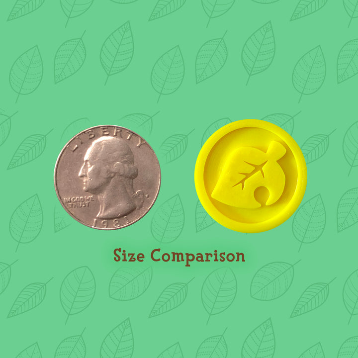 3d printed yellow coin with leaf icon next to quarter for size