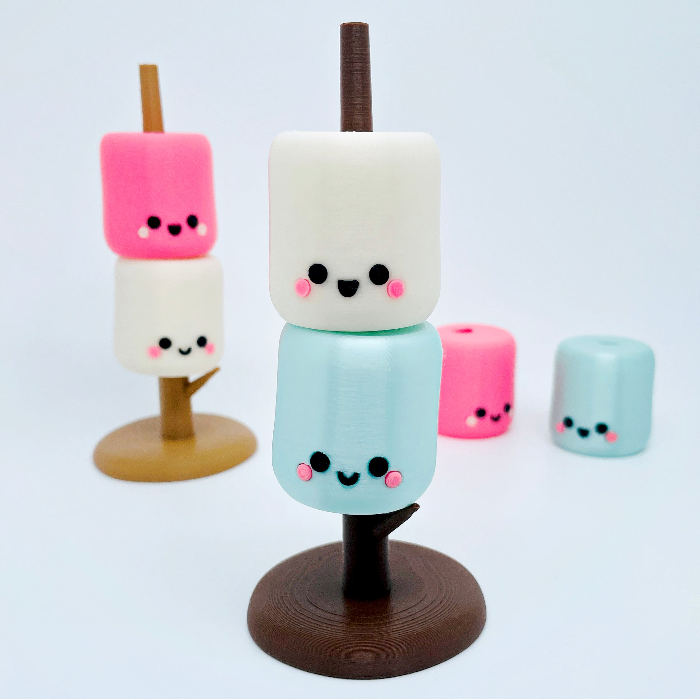 Marshmallow treats with cute face designs on a white background