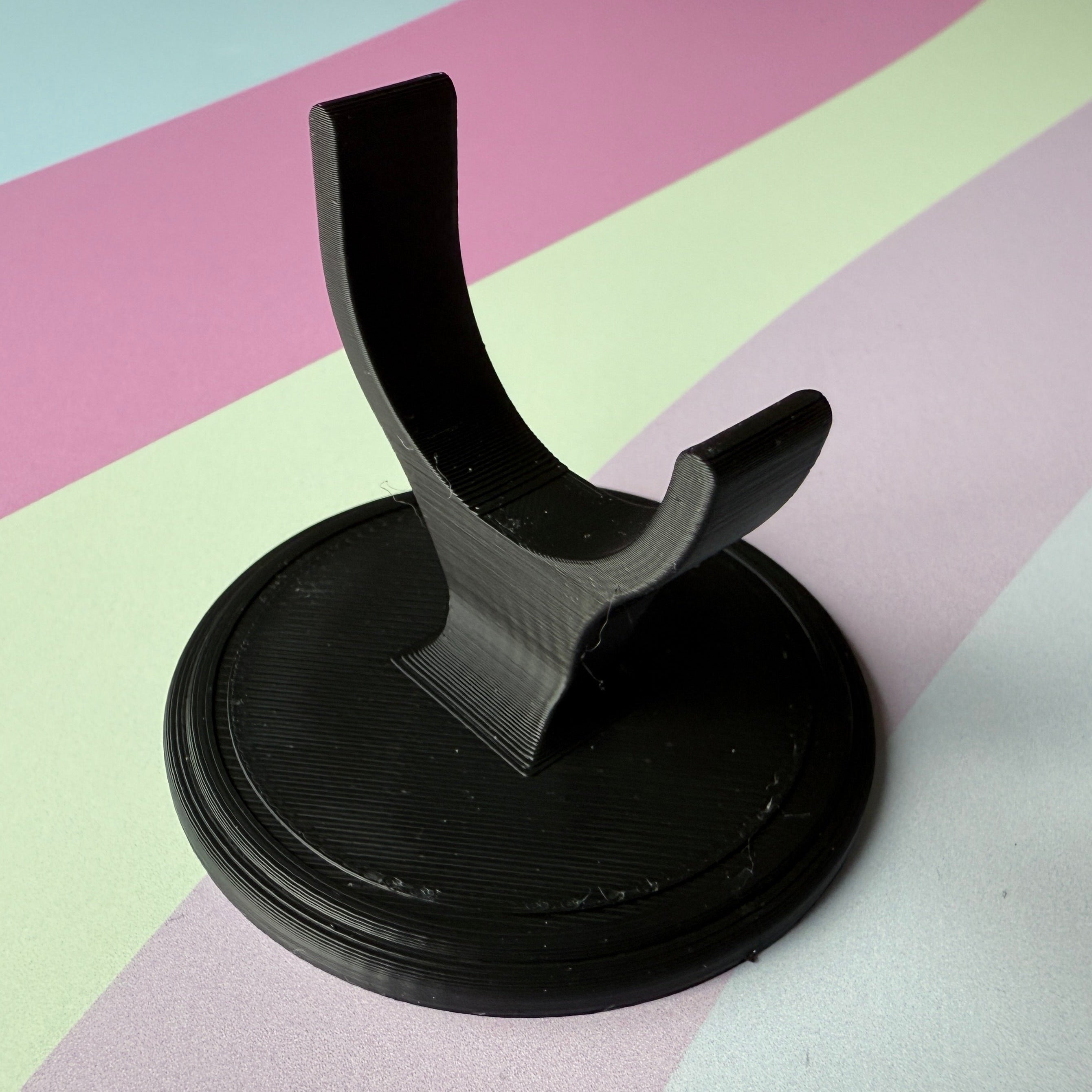 Black display stand on a striped background