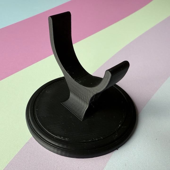 Black display stand on a striped background