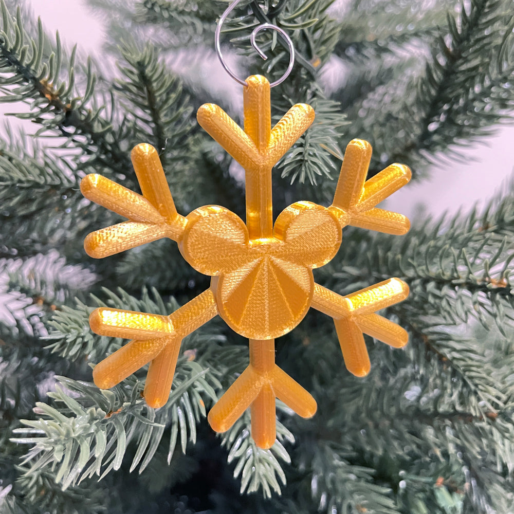 Gold snowflake-shaped ornament on a Christmas tree