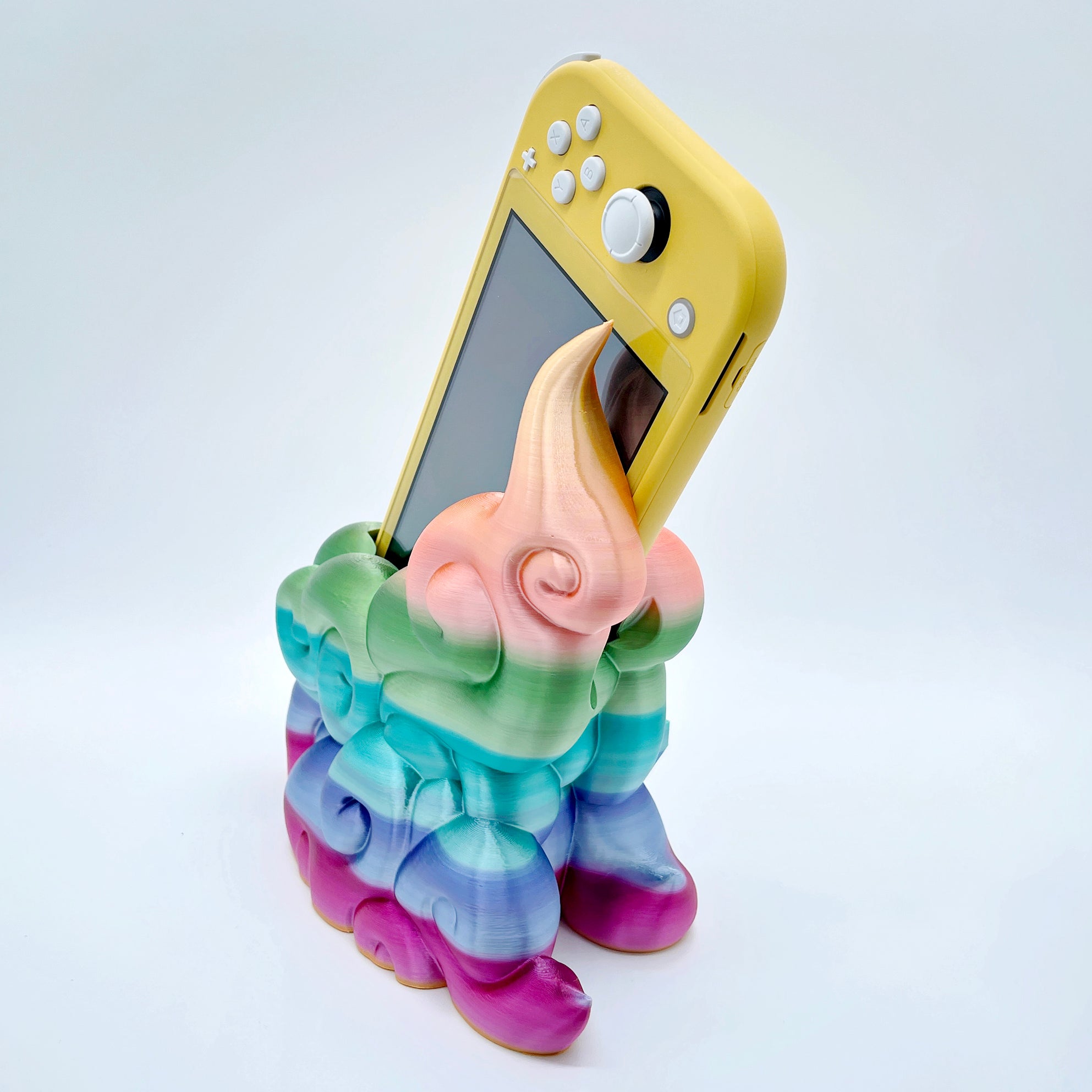 Rainbow gradient 3D printed cloud-style dock for compact handheld console on white background.