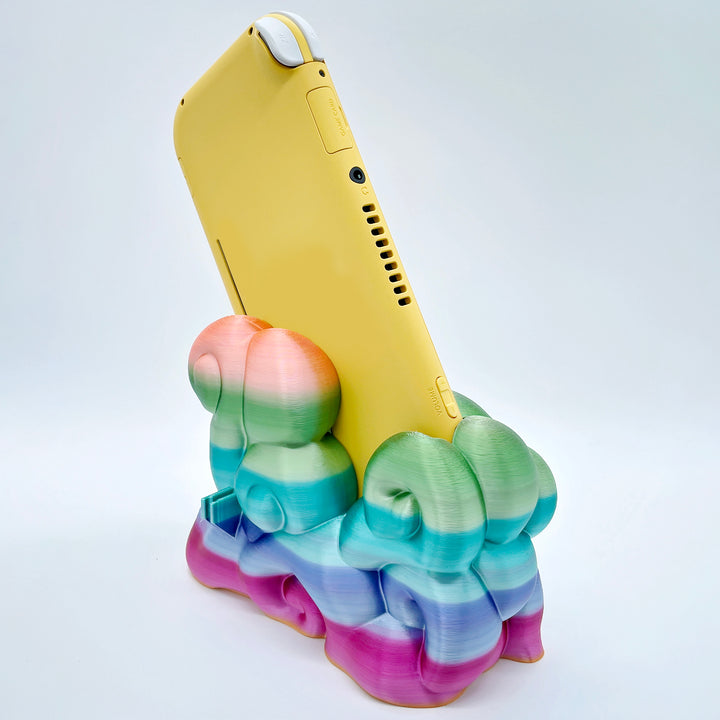 Rainbow gradient 3D printed cloud-style dock for compact handheld console on white background