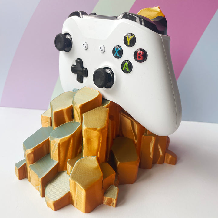 White gaming controller on sun-kissed quartz 3D printed controller stand on white background against a colorful background
