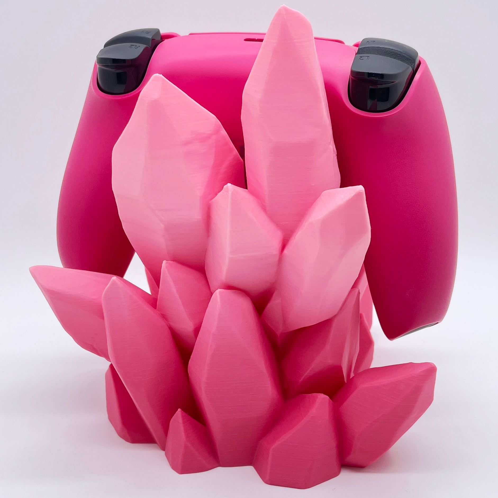 Pink ombre 3D printed crystal-style controller stand with a pink and black controller on a white background